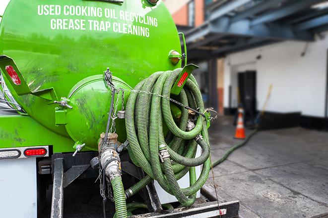 a technician pumping a grease trap in a commercial building in Akron